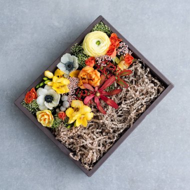 Gri arka planda hediye kutusunda çiçekler. Eski ahşap kırsal kutuda çeşitli çiçeklerden bir buket, üst manzara. Düz yatıyordu. Metin için boşluğu kopyala