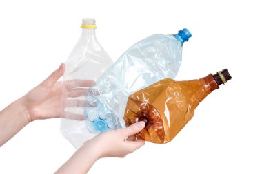Beyaz üzerine izole edilmiş farklı tipte ezilmiş plastik şişeleri tutan kadın eller. Geri dönüşümlü atık. Geri dönüşüm, yeniden kullanım, çöp öğütücü, kaynaklar, çevre ve ekoloji kavramı.