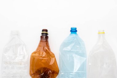 Beyaz arka planda farklı tipte ezilmiş plastik şişeler. Metin için kopyalanma alanı. Geri dönüşümlü atık. Geri dönüşüm, yeniden kullanım, çöp öğütücü, kaynaklar, çevre ve ekoloji kavramı