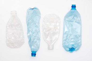 Açık arkaplanda ezilmiş plastik şişeler.