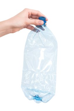 Beyaz üzerine izole edilmiş ezilmiş mavi plastik şişeyi tutan kadın eli. Geri dönüşümlü atık. Geri dönüşüm, yeniden kullanım, çöp öğütücü, kaynaklar, çevre ve ekoloji kavramı.