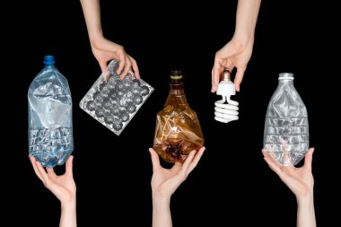 Boş ezilmiş plastik atıkları tutan kadın eller, siyah arka planda izole edilmiş lamba. Geri dönüşümlü atık. Geri dönüşüm, yeniden kullanım, çöp öğütücü, kaynaklar, çevre ve ekoloji kavramı