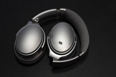 Müzik kulaklıkları. Stereo hacimli ekipman nesnesi. Siyah arka plandaki kulaklıklar ve metin için telif alanı. Ses teknolojisi, cihazlar ve müzik konsepti