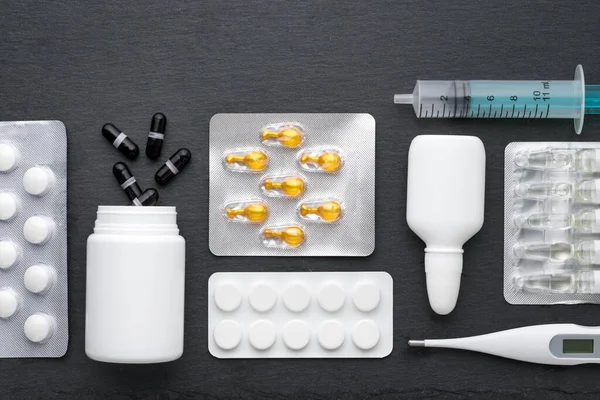 Termometer Näsdroppar Tabletter Och Ampuller Med Läkemedel Svart Skiffertavla Ovanifrån — Stockfoto