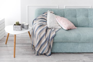 Modern ahşap sehpa ve yastıklı rahat kanepe. Oturma odası iç mekan ve basit modern ev dekorasyonu.