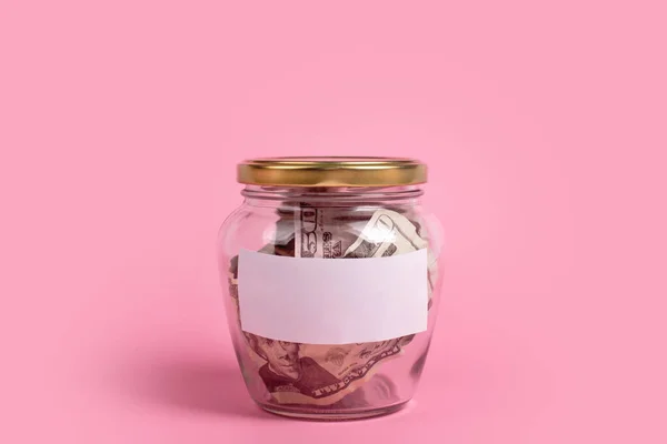 American dollars in glass money jar with blank label, financial, saving. Money box with empty sticky note paper. Jar full of cash, save money concept, expense planning and control, free space for text