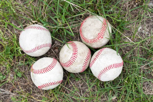 Primer plano pelotas de béisbol usadas en el campo de hierba verde, concepto de deporte —  Fotos de Stock