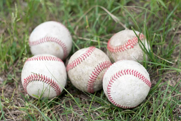 Close-up używane piłki bazowe na polu zielonej trawy, koncepcja sportowa — Zdjęcie stockowe