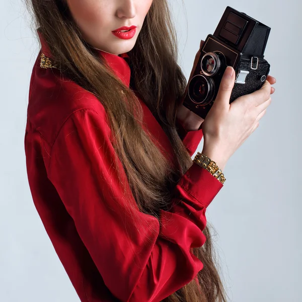 Woman in red with rarity old photographic camera closeup