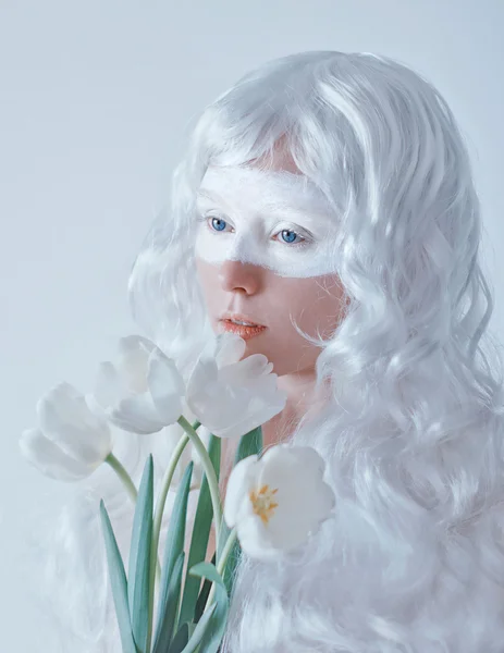 Spring fairy. Young woman in white wig with bouquet of tulips on white background. — Stock Photo, Image