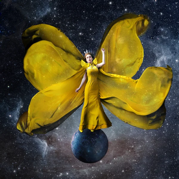 Reina del espacio amarillo. Hermosa mujer con un vestido ondulado de pie y equilibrándose en el planeta en el espacio exterior. Fantástica obra de arte. Elementos de esta imagen proporcionados por la NASA . —  Fotos de Stock
