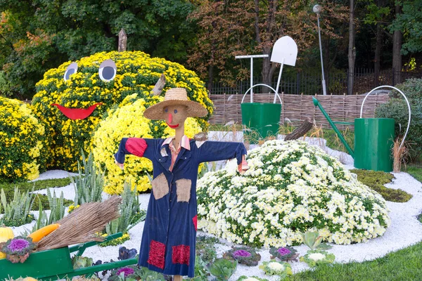 Moestuin, bewaakt door een vogelverschrikker. Grote cijfers gemaakt van bloemen in de vorm van groenten met kleurrijke chrysanten. Parkland in Kiev, Oekraïne. — Stockfoto