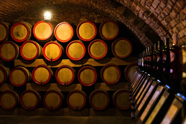 Vin fat i den antika vinkällaren. Cavernous vinkällare med staplade ekfat för att mogna röda vin. Selektiv inriktning. — Stockfoto