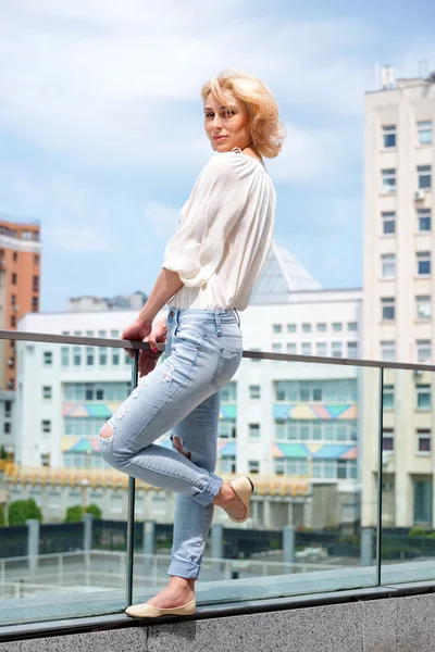 Outdoor summer fashion stunning portrait on pretty young blonde sexy woman dressed in a white shirt and torn jeans having fun in the street — Stock Photo, Image