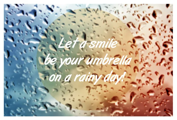 Inspirational quote with words Let a smile be your umbrella on blurred natural background with water drops on window glass texture. — Stock Photo, Image