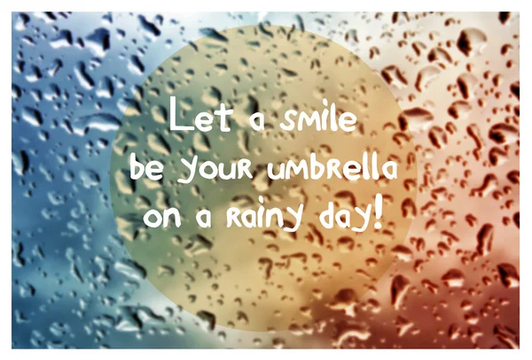 Inspirational quote with words Let a smile be your umbrella on blurred natural background with water drops on window glass texture. — Stok fotoğraf