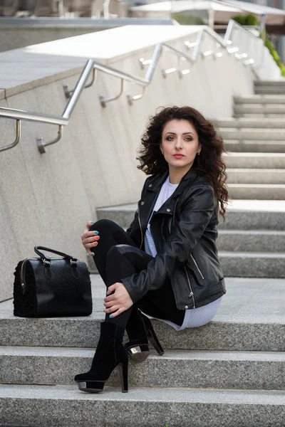 Glamorous young brunette woman in black leather jacket having fun in the city. — Stock Photo, Image