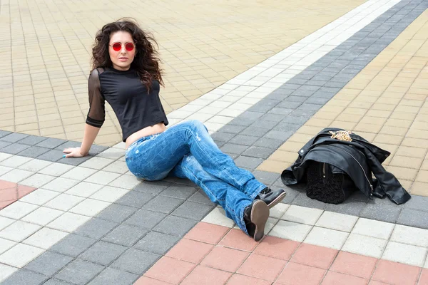 Glamour giovane donna bruna in tondo occhiali da sole rossi divertirsi in città . — Foto Stock
