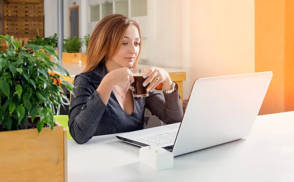 Επιχειρηματική, τεχνολογική και πράσινη ιδέα γραφείου-νέος επιτυχημένος επιχειρηματίας με φορητό υπολογιστή στο γραφείο. Γυναίκα που χρησιμοποιεί υπολογιστή tablet ή διάλειμμα για καφέ. — Φωτογραφία Αρχείου