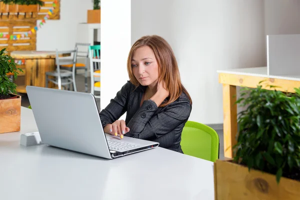 Business, technologie en groen kantoor concept - jonge succesvolle zakenvrouw met laptop op kantoor. Vrouw met tabletcomputer. — Stockfoto