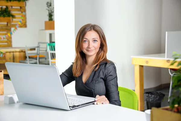 Business, technologie en groen kantoor concept - jonge succesvolle zakenvrouw met laptop op kantoor. Vrouw met tabletcomputer. — Stockfoto