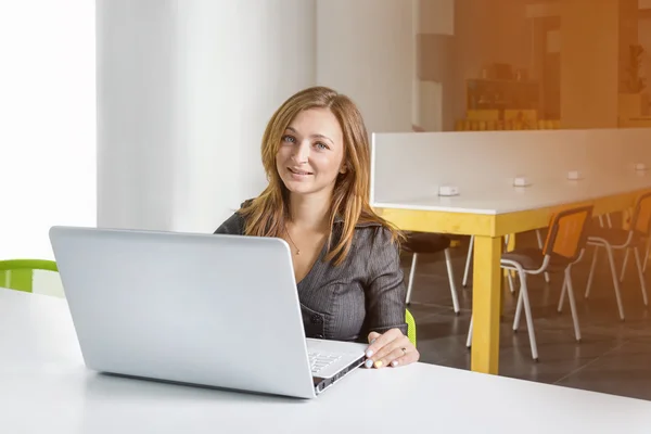 Business, technologie en groen kantoor concept - jonge succesvolle zakenvrouw met laptop op kantoor. Vrouw met tabletcomputer. — Stockfoto