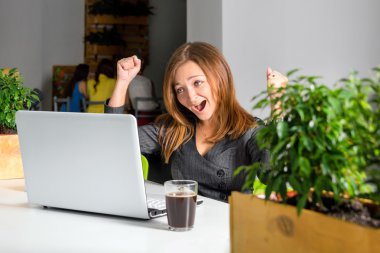 Onu başarı kutluyor laptop ile masadan kaldırdı kollarını heyecanlı mutlu işkadını. Yeşil Eko office kavramı.