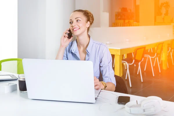 Business, technologie en green office concept - jonge succesvolle zakenvrouw met laptopcomputer praten over de telefoon op kantoor. Mooie vrouw met behulp van tablet pc. — Stockfoto
