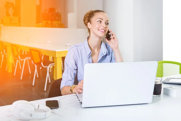 Business, technologie en green office concept - jonge succesvolle zakenvrouw met laptopcomputer praten over de telefoon op kantoor. Mooie vrouw met behulp van tablet pc. — Stockfoto