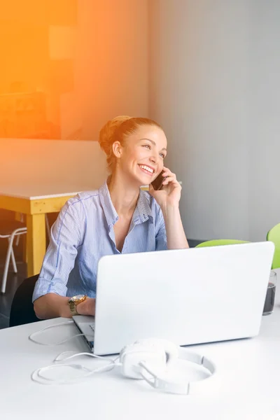 Business, technologie en green office concept - jonge succesvolle zakenvrouw met laptopcomputer praten over de telefoon op kantoor. Mooie vrouw met behulp van tablet pc. — Stockfoto