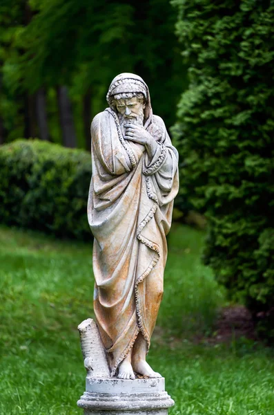 Marmor park skulptur av en gammal man fryser och insvept i täcken personifierar den kalla årstiden år. Slotten och parkerar komplex Manor Tarnowski, s.Kachanovka, Ukraina. — Stockfoto