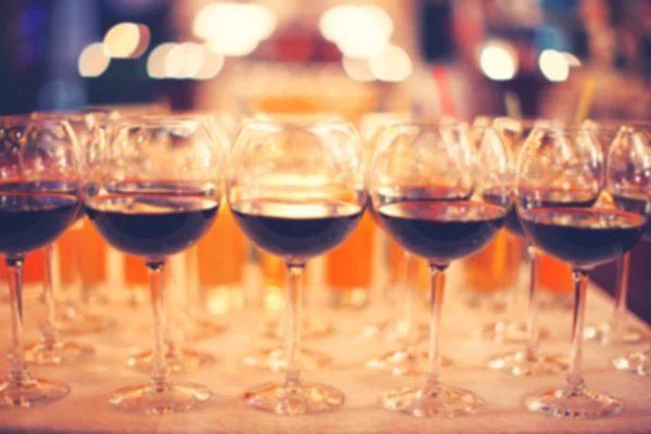 Blurred background with glasses of wine, standing in a row — Stock Photo, Image