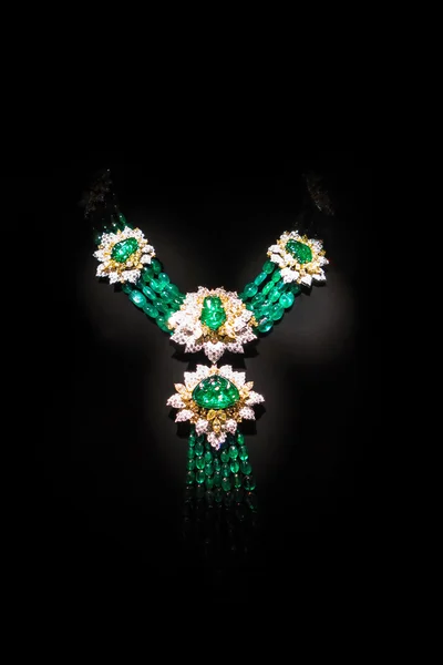 Halskette aus Gelbgold mit Diamanten und Smaragden auf einem Ständer. — Stockfoto