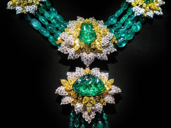 Colar feito de ouro amarelo com diamantes e esmeraldas em um suporte . — Fotografia de Stock