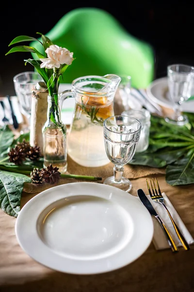 Una jarra de bebida afrutada con menta y limón en una mesa decorada lista para la cena. Conjunto de mesa bellamente decorado para boda u otro evento en el restaurante . —  Fotos de Stock