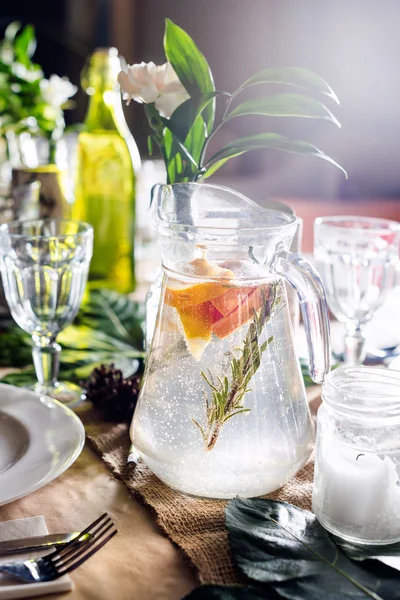 Una jarra de bebida afrutada con menta y limón en una mesa decorada lista para la cena. Conjunto de mesa bellamente decorado para boda u otro evento en el restaurante . —  Fotos de Stock