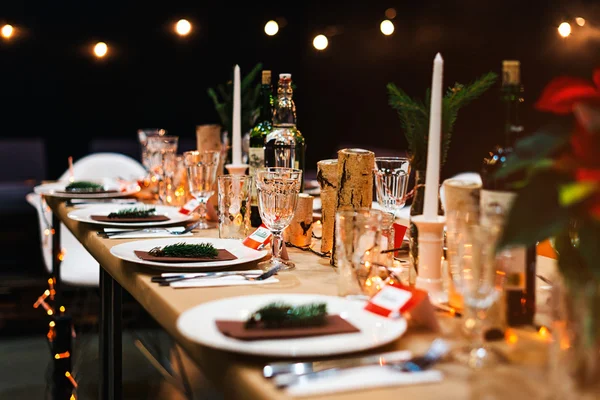 Mesa navideña decorada lista para la cena. Mesa bellamente decorada con velas, ramitas de abeto, platos y servilletas para eventos en el restaurante. —  Fotos de Stock