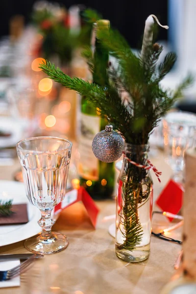 Mesa navideña decorada lista para la cena. Mesa bellamente decorada con velas, ramitas de abeto, platos y servilletas para eventos en el restaurante. —  Fotos de Stock