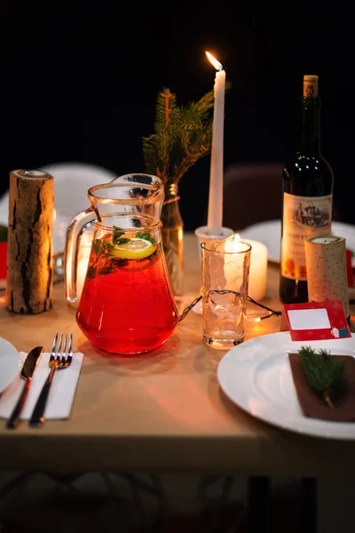 Decorated Christmas holiday table ready for dinner. Beautifully decorated table set with candles, spruce twigs, plates and serviettes for event in the restaurant.