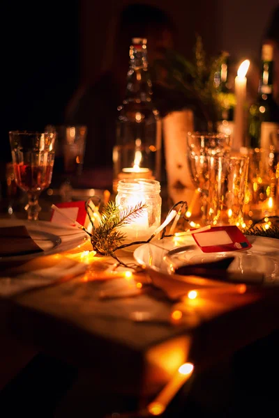 Decorated Christmas holiday table ready for dinner. Beautifully decorated table set with candles, spruce twigs, plates and serviettes for event in the restaurant. Stock Image