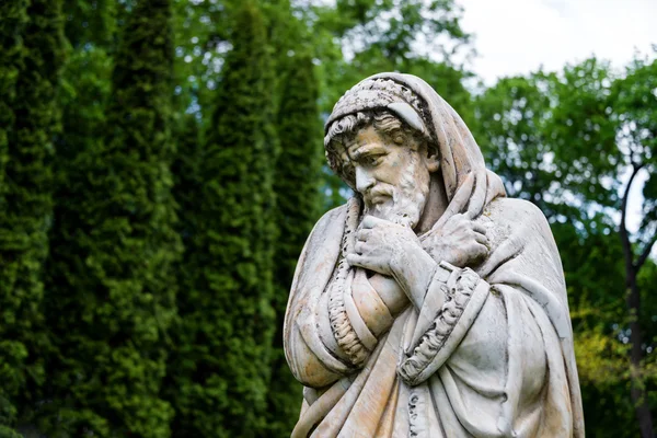 Marmor park skulptur av en gammal man fryser och insvept i täcken personifierar den kalla årstiden år. Slotten och parkerar komplex Manor Tarnowski, s.Kachanovka, Ukraina. — Stockfoto