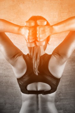 Spor salonunda bir beton duvar arka plan üzerinde ağırlıkları ile egzersiz kadın uygun. Sağlıklı yaşam konsepti.