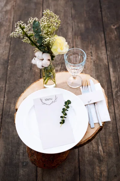 Paper menu on decorated table ready for dinner. Beautifully decorated table set with flowers, plates and serviettes for outdoor wedding ceremony or another event in the restaurant. — 스톡 사진
