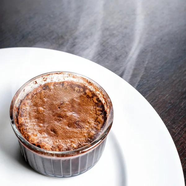 Bolo de lava de fondant de chocolate de sobremesa quente recém-assado servido em prato branco. Sobremesa francesa famosa na vista superior da mesa de madeira escura . — Fotografia de Stock