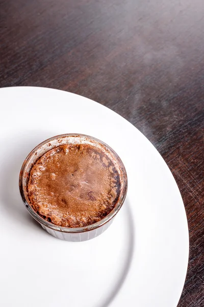 Bolo de lava de fondant de chocolate de sobremesa quente recém-assado servido em prato branco. Sobremesa francesa famosa na vista superior da mesa de madeira escura . — Fotografia de Stock