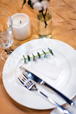 Decorated table ready for dinner. Beautifully decorated table set with flowers, plates and serviettes for wedding or another event in the restaurant. Selective focus.