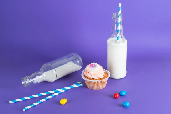Cupcake for Valentine's Day with hearts on top of whipped cream and milk cocktails with retro cocktail tubes, served in bottles on colourful background. — Stock Photo, Image