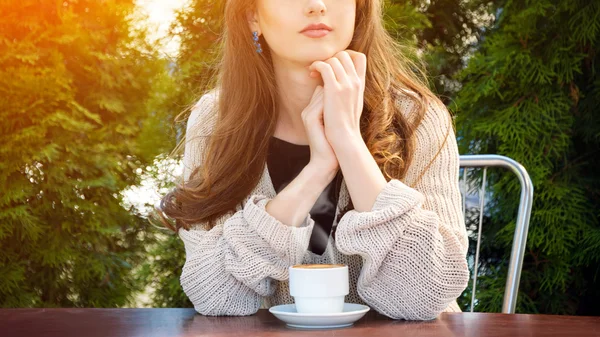 Beautiful young woman drinking hot coffee in summer garden. — Stock Photo, Image