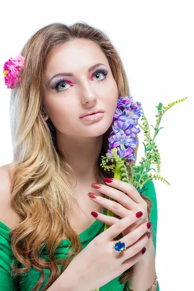 Beautiful blonde girl with bright makeup, long curled hair and massive jewelry holding a blossoming branch isolated on white background. Fashion shot. — Stock Photo, Image