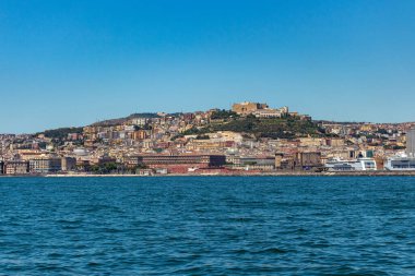 İtalya 'nın Napoli kıyı şeridinden deniz manzarası. Büyük yolcu gemileri limanda, güneşli havada şehir manzarası mavi gökyüzü ve beyaz bulutlarla.